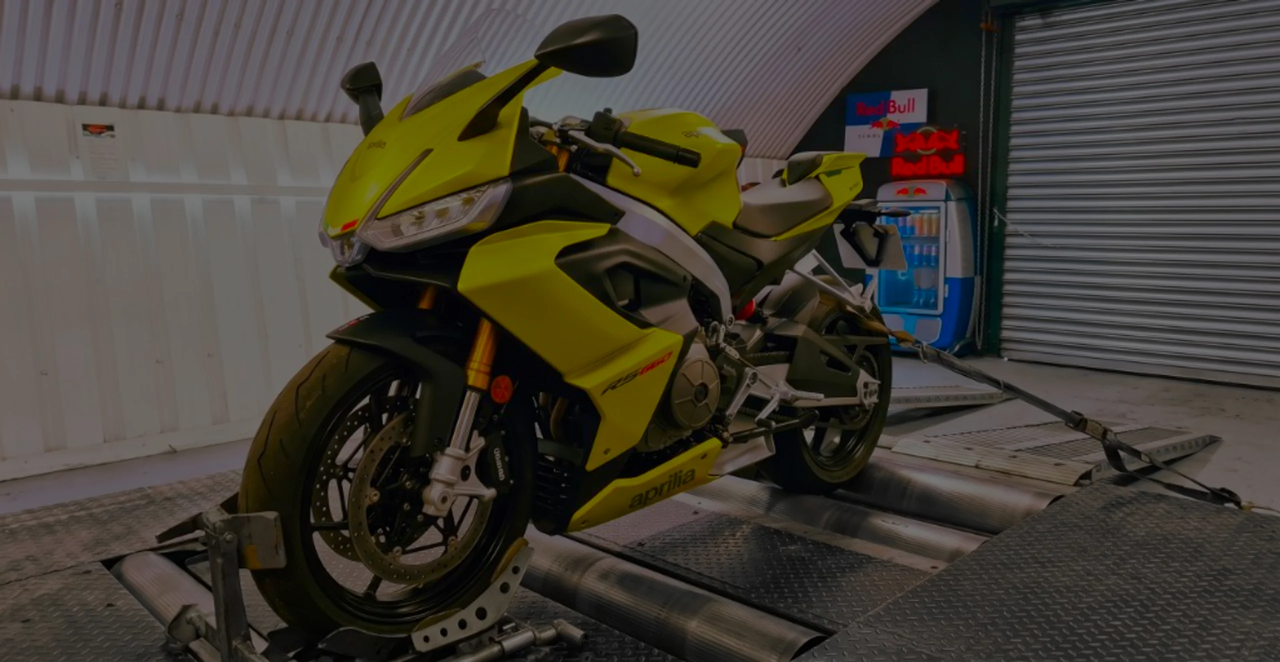 Acid gold Aprilia RS 660 front three-quarter on motorcycle rolling road dyno with RS 660 fairing lettering at 24Tuning Bournemouth Dorset workshop for Stage 1 ECU remapping