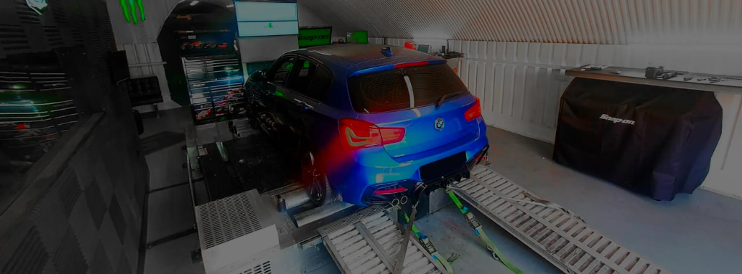 Blue BMW 118d F20 front three-quarter on Dynocom rolling road dyno at 24Tuning Bournemouth Dorset workshop for Stage 1 ECU remapping