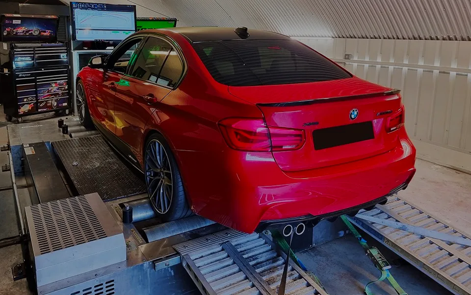 Red BMW 320d F30 xDrive rear on rolling road dyno with performance graph on monitor at 24Tuning Bournemouth Dorset