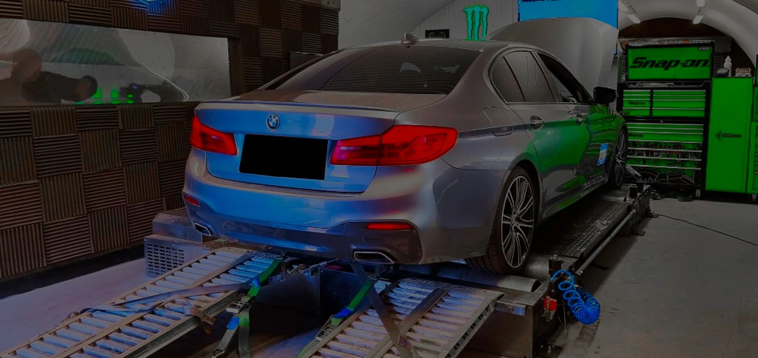 Silver BMW 520d G30 rear three-quarter on Dynocom rolling road dyno with bonnet open at 24Tuning Bournemouth Dorset workshop for Stage 1 ECU remapping