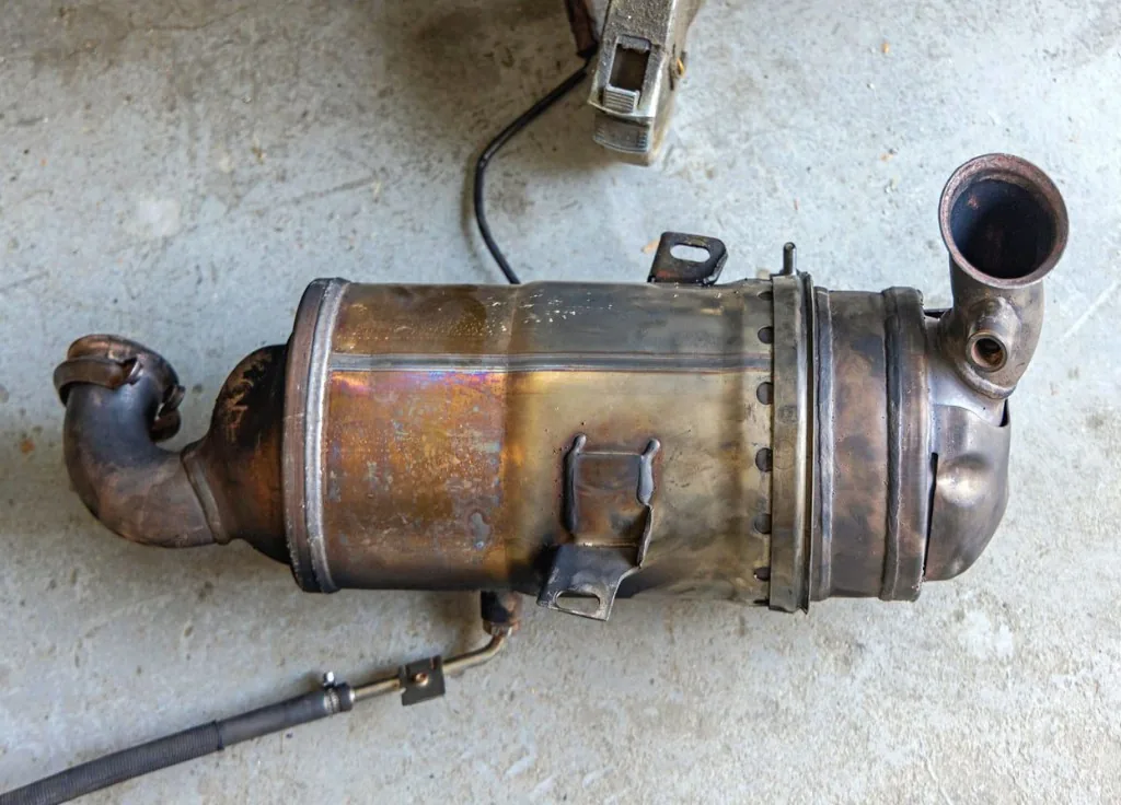 Used DPF canister removed from a vehicle on a workshop floor — Bournemouth Dorset