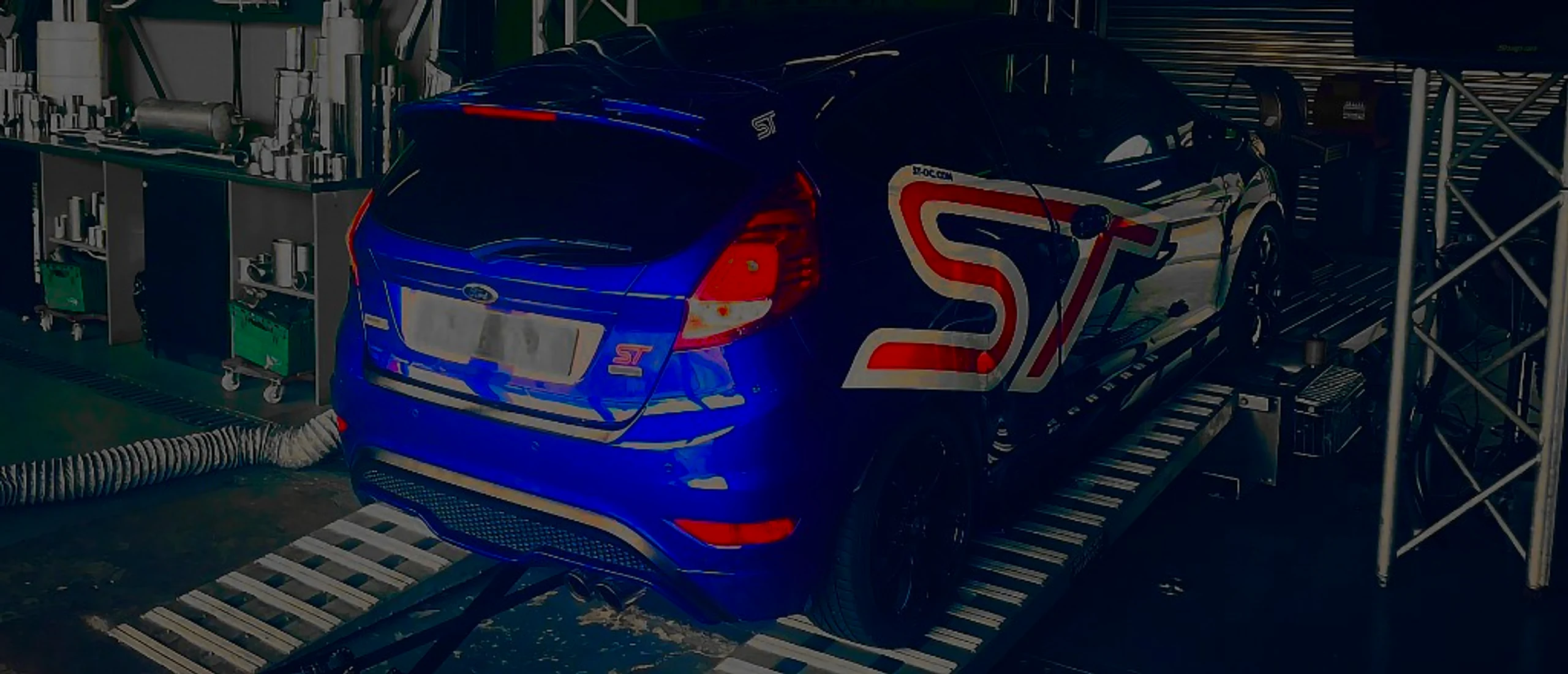 Ford Fiesta ST 1.6 EcoBoost Remap Bournemouth Poole Dorset | 24Tuning Blue Ford Fiesta ST 1.6 EcoBoost rear three-quarter on Dynocom rolling road dyno at 24Tuning Bournemouth Dorset workshop for Stage 1 ECU remapping