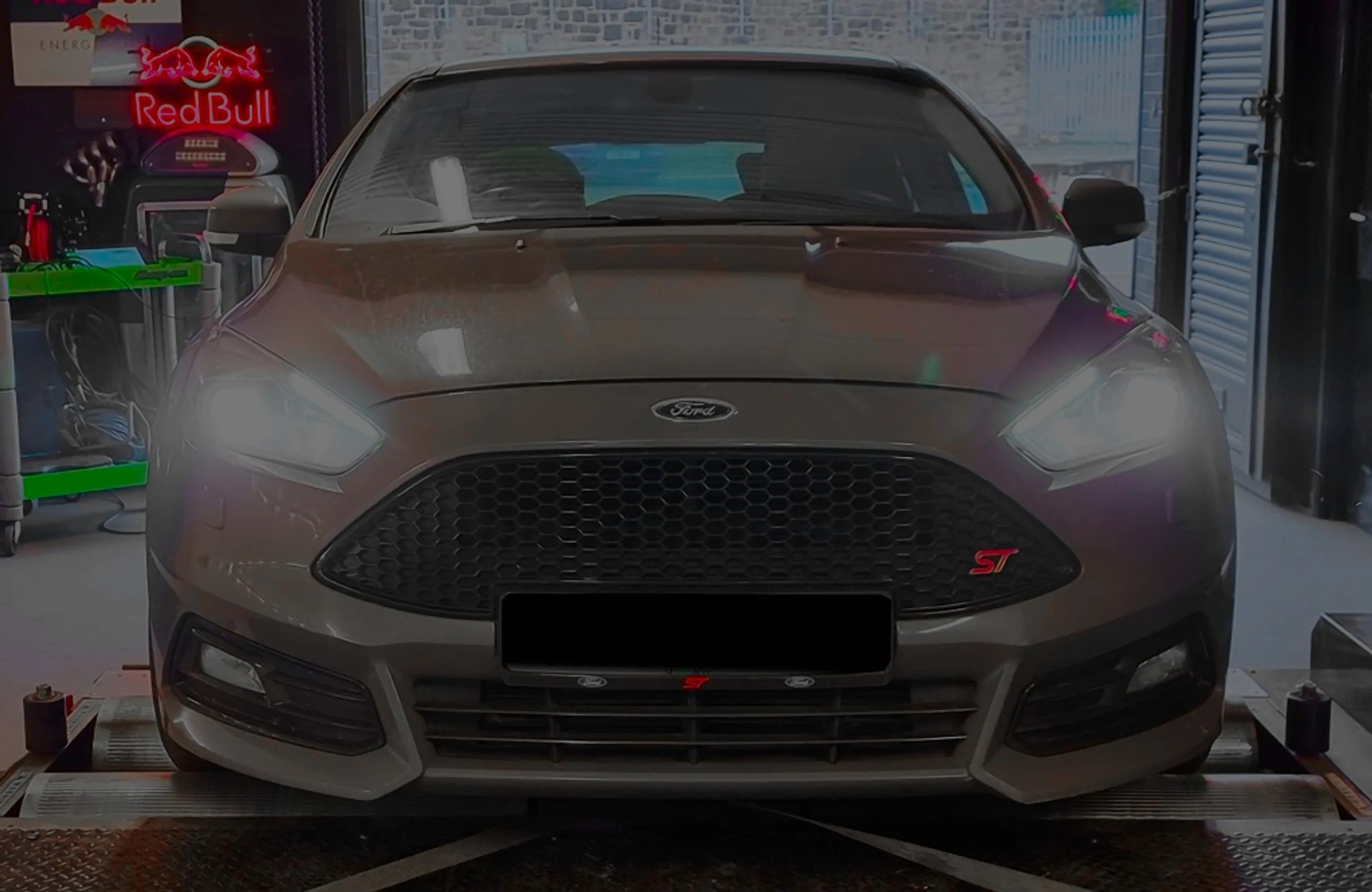 Grey Ford Focus ST 2.0 TDCi Mk3 front on rolling road dyno with headlights on at 24Tuning Bournemouth Dorset workshop for Stage 1 ECU remapping