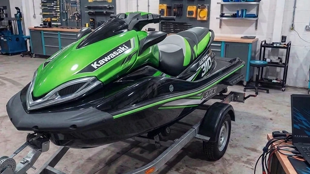 Green Kawasaki Ultra 310 jet ski on a trailer in the 24Tuning Bournemouth Dorset workshop with ECU remapping laptop - jet-ski tuning by 24Tuning