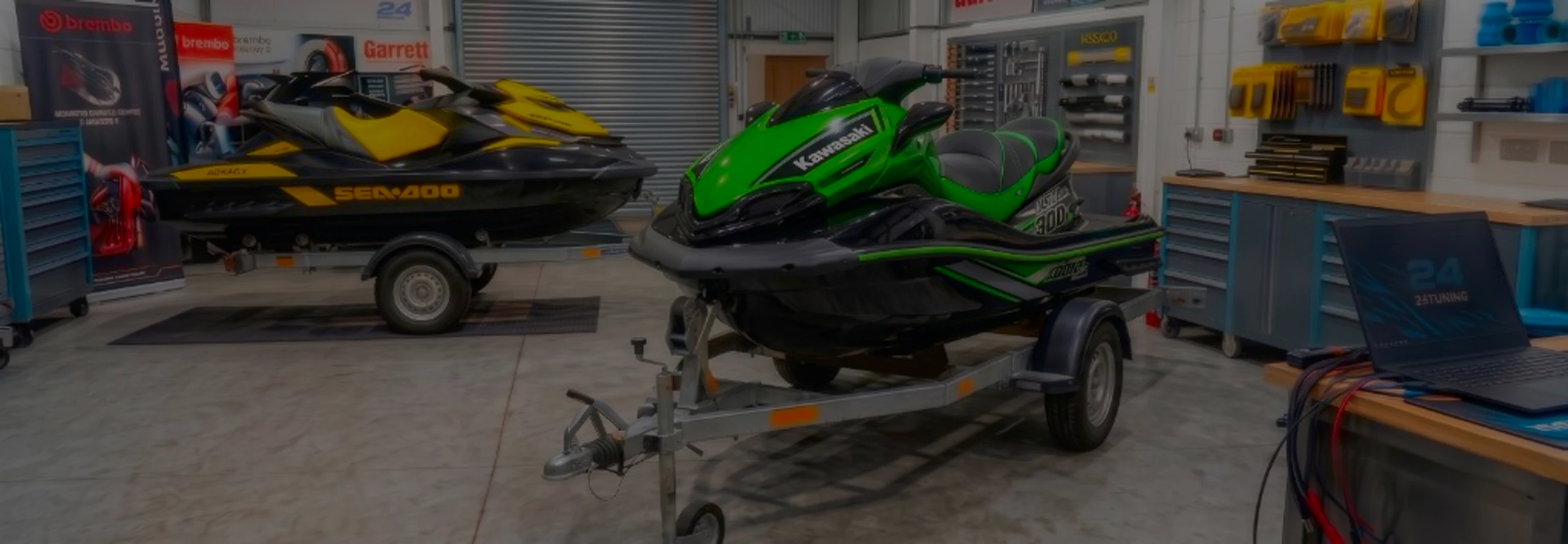 Green Kawasaki Ultra 300X jet ski on a trailer in the 24Tuning Bournemouth Dorset workshop with ECU remapping laptop and tuning cables for Stage 1 calibration