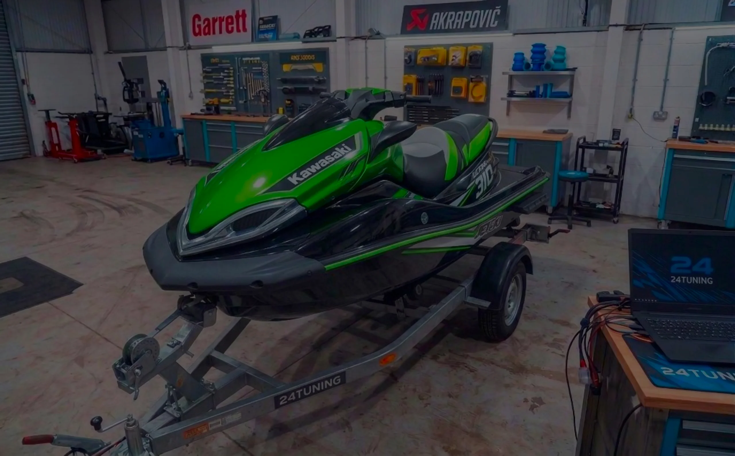 Green Kawasaki Ultra 310LX-S jet ski on a trailer in the 24Tuning Bournemouth Dorset workshop with diagnostic laptop and ECU remap screen for Stage 1 PWC tuning