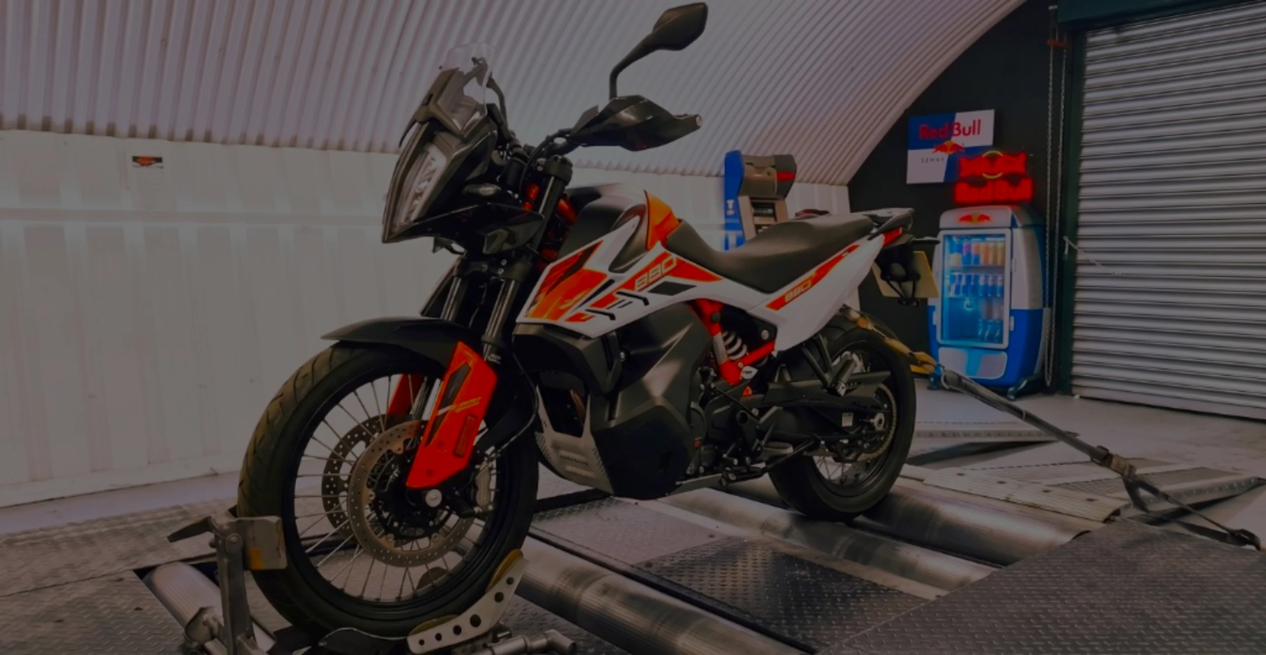 White and orange KTM 890 Adventure front three-quarter on motorcycle rolling road dyno with 890 fairing lettering at 24Tuning Bournemouth Dorset workshop for Stage 1 ECU remapping