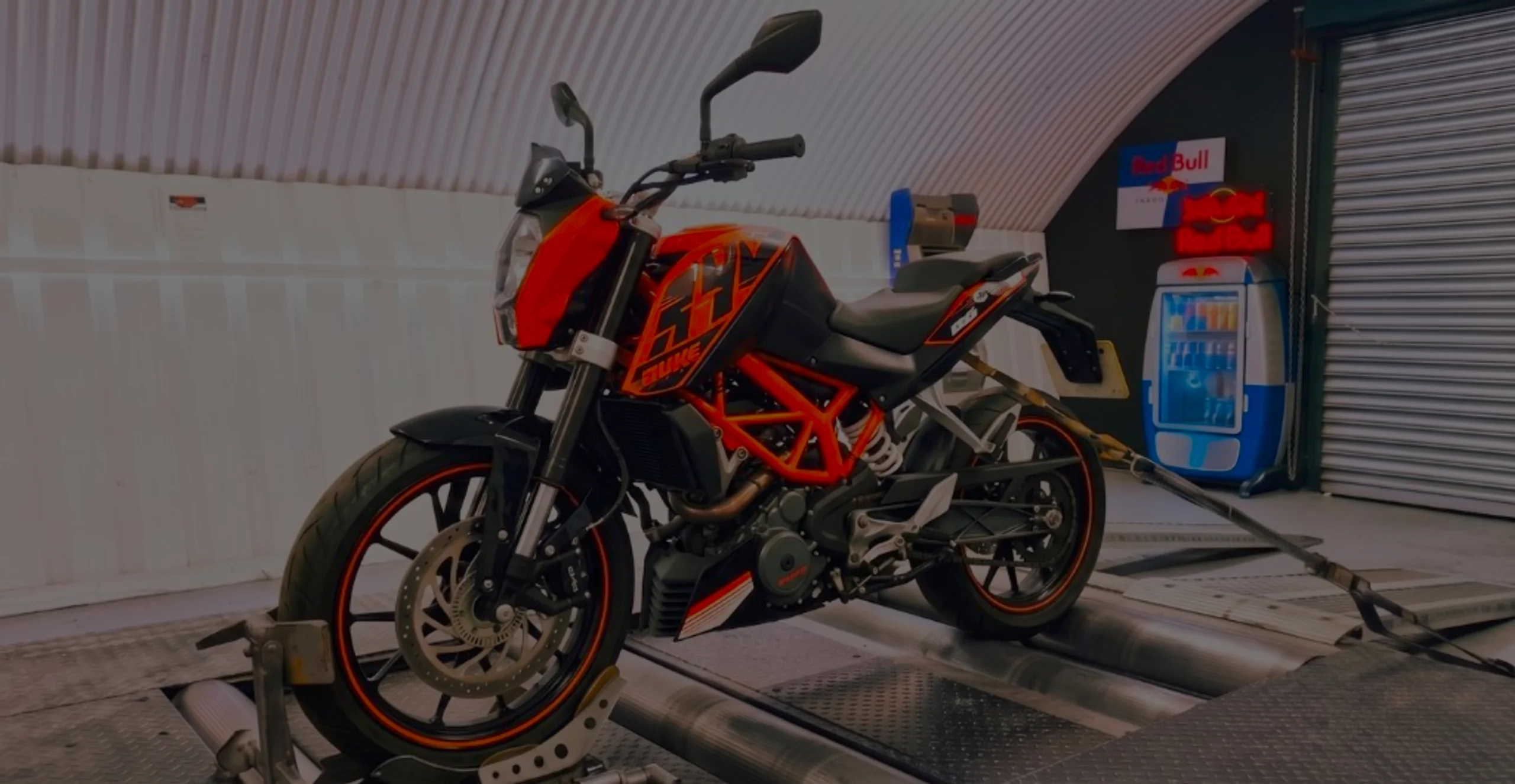 KTM Duke 125 Remap Bournemouth Poole Dorset | 24Tuning Orange and black KTM Duke 125 front three-quarter on motorcycle rolling road dyno with DUKE fairing lettering at 24Tuning Bournemouth Dorset workshop for Stage 1 ECU remapping