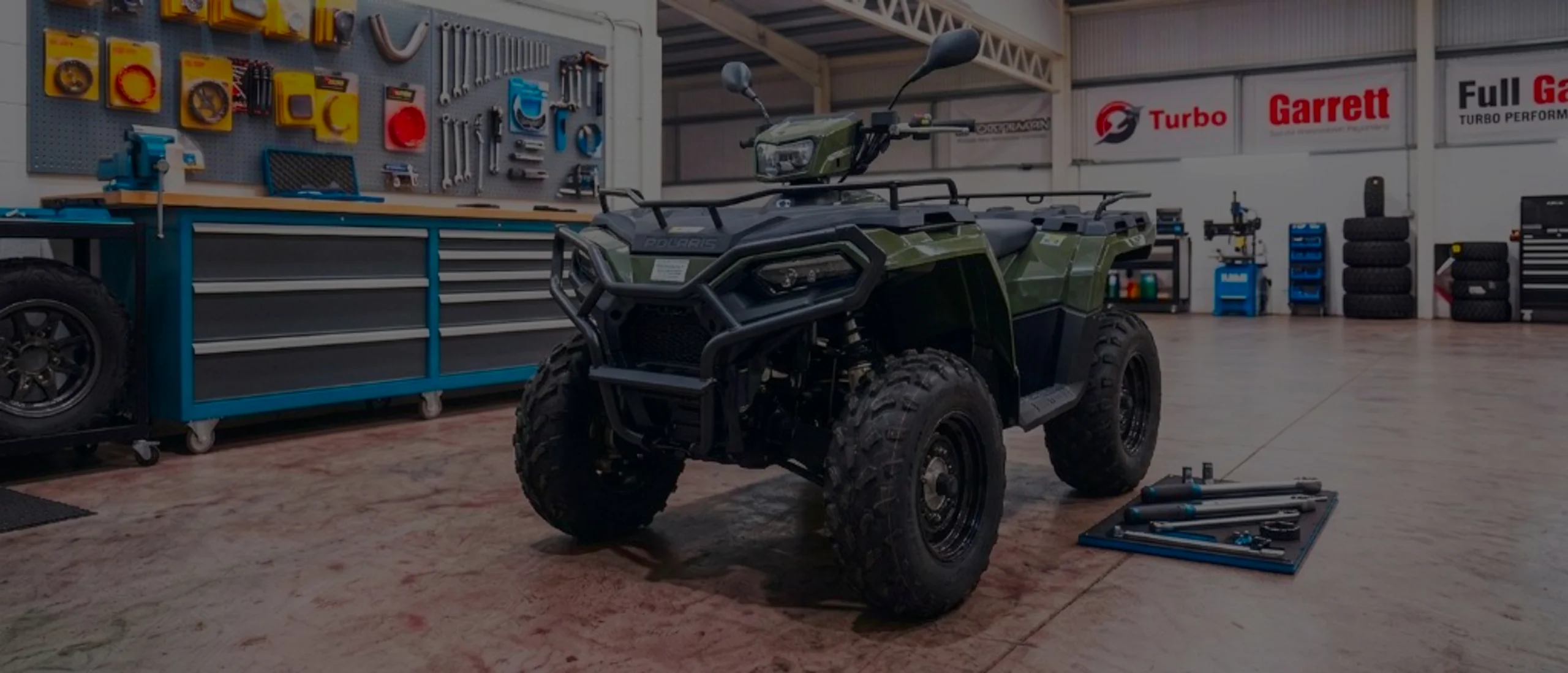 Olive green Polaris Sportsman 570 in 24Tuning Bournemouth Dorset workshop with tool chest, Garrett turbo banner and torque wrenches for Stage 1 ECU remapping