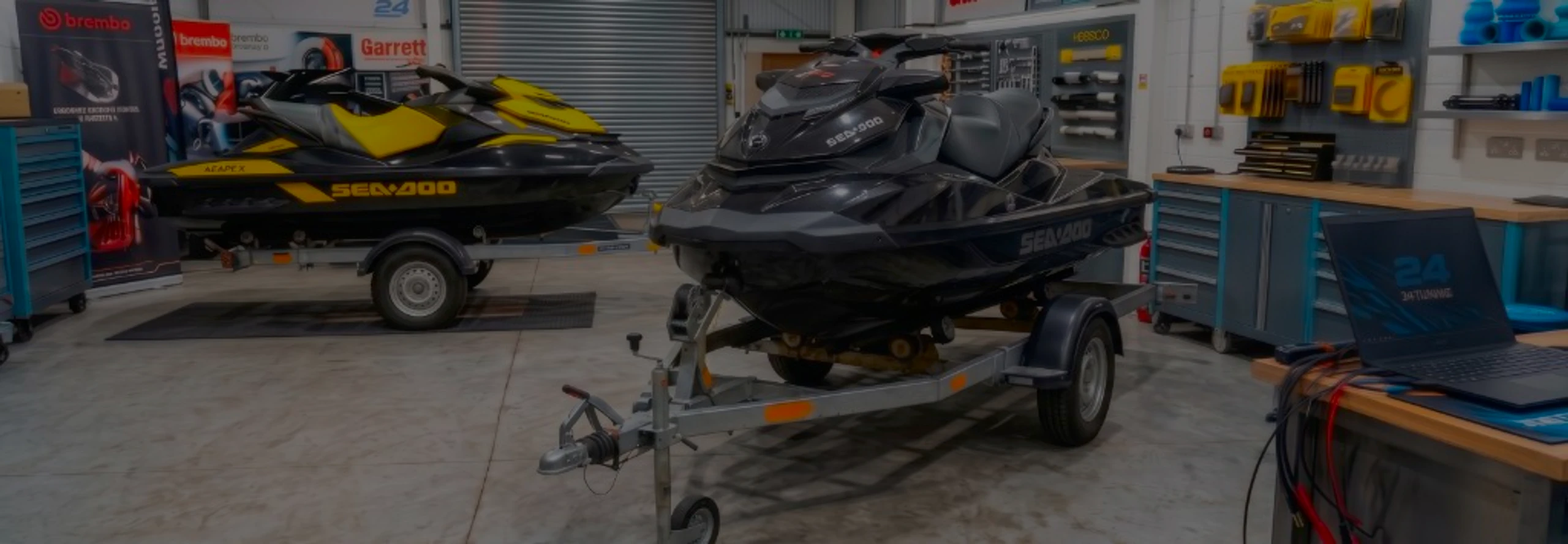 Black Sea-Doo RXP-X jet ski on a trailer in the 24Tuning Bournemouth Dorset workshop with ECU remapping laptop and tuning cables for Stage 1 calibration
