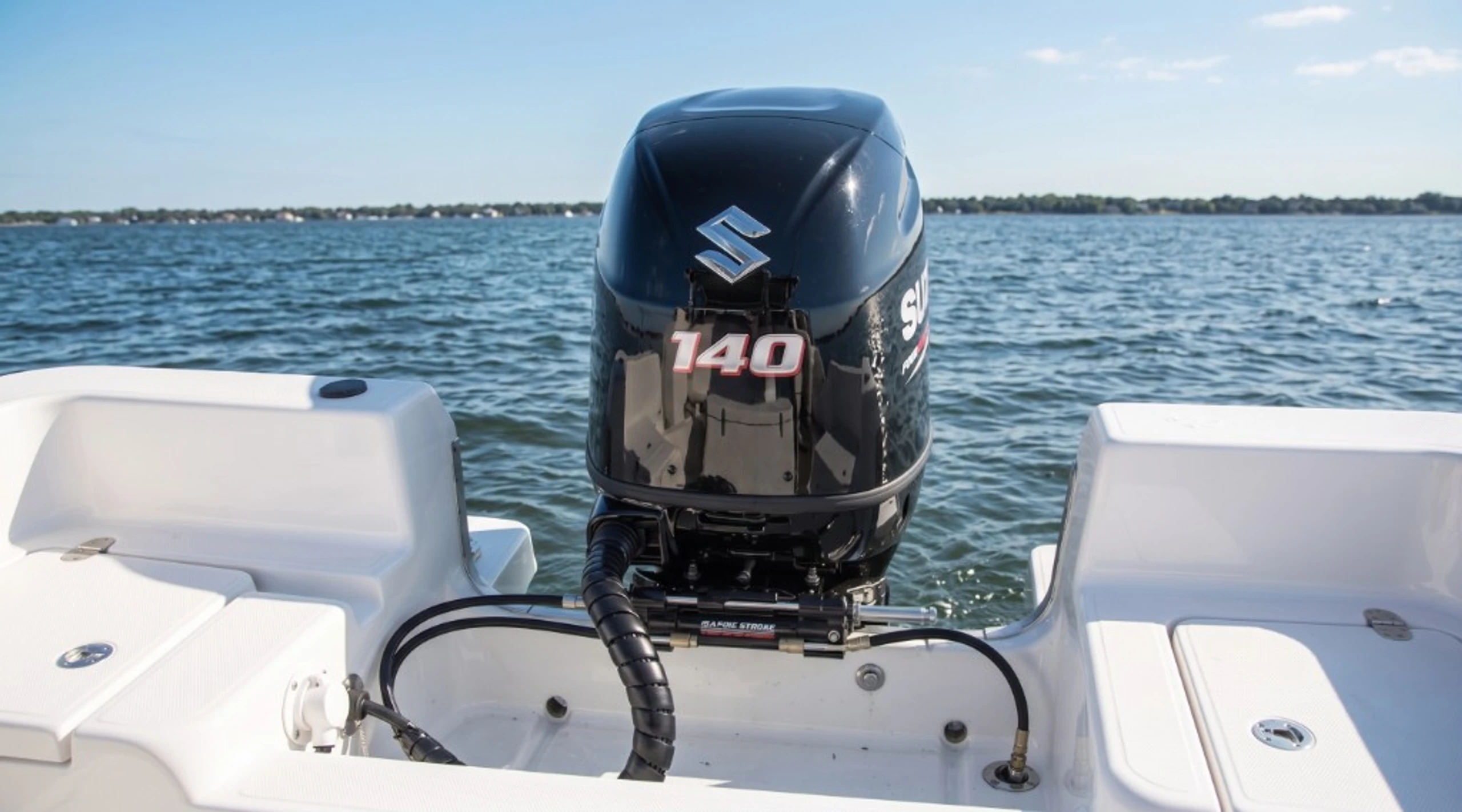 Suzuki DF140 outboard motor on a white boat stern with open Dorset coastal water for marine Stage 1 ECU remapping by 24Tuning Bournemouth Poole
