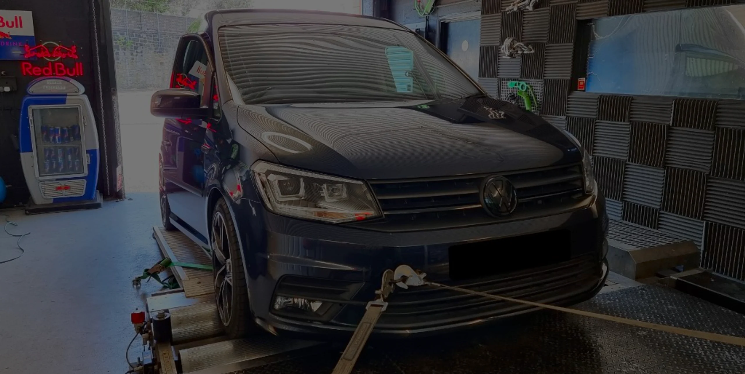 Dark grey Volkswagen Caddy Mk4 front three-quarter on rolling road dyno with front strap secured at 24Tuning Bournemouth Dorset workshop for Stage 1 ECU remapping