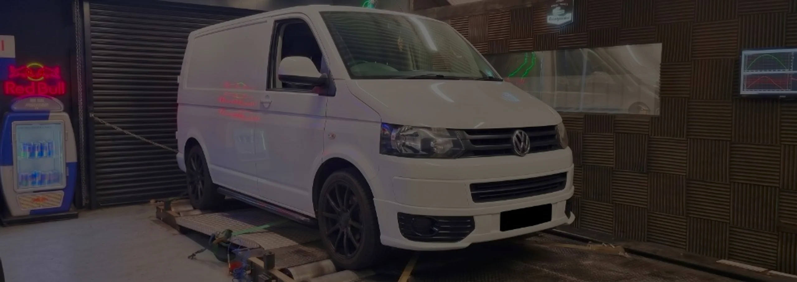 VW Transporter T5 2.0 TDI Remap Bournemouth Poole Dorset | 24Tuning White Volkswagen Transporter T5 front three-quarter on rolling road dyno with green safety straps at 24Tuning Bournemouth Dorset workshop for Stage 1 ECU remapping