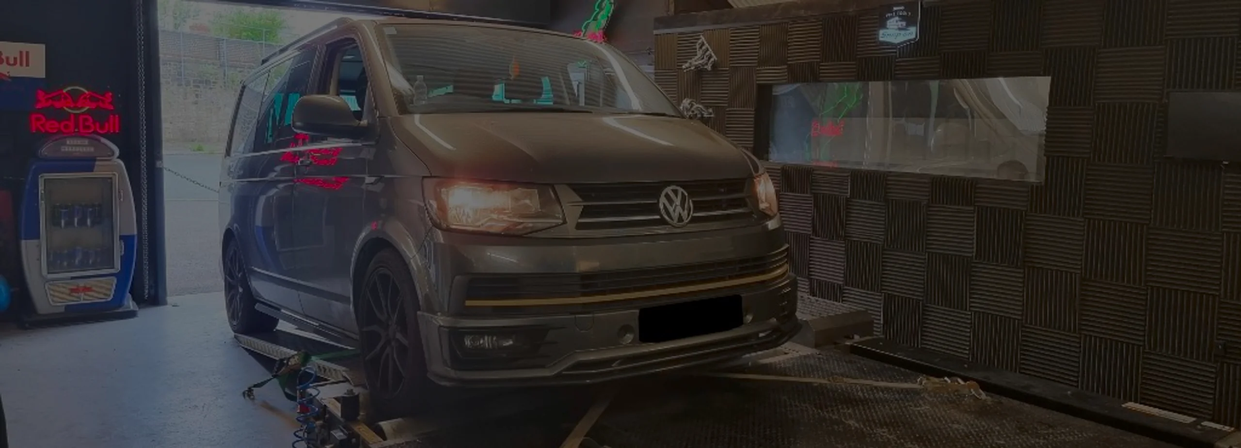 Grey Volkswagen Transporter T6 front three-quarter on rolling road dyno with headlights on at 24Tuning Bournemouth Dorset workshop for Stage 1 ECU remapping