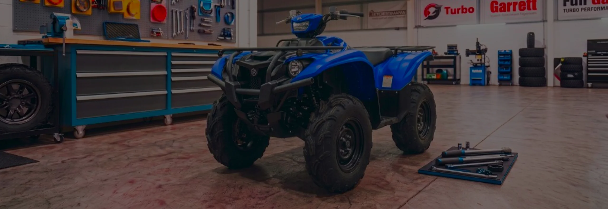 Yamaha Kodiak 700 Remap Bournemouth Poole Dorset | 24Tuning Blue Yamaha Kodiak 700 in 24Tuning Bournemouth Dorset workshop with tool chest, Garrett turbo banner and torque wrenches for Stage 1 ECU remapping