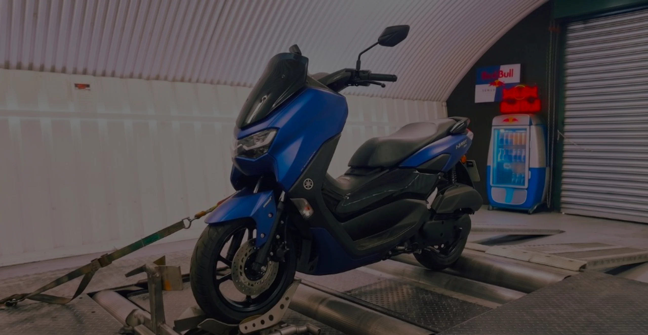 Matte blue Yamaha N-Max 125 front three-quarter on motorcycle rolling road dyno with NMAX fairing badge at 24Tuning Bournemouth Dorset workshop for Stage 1 ECU remapping